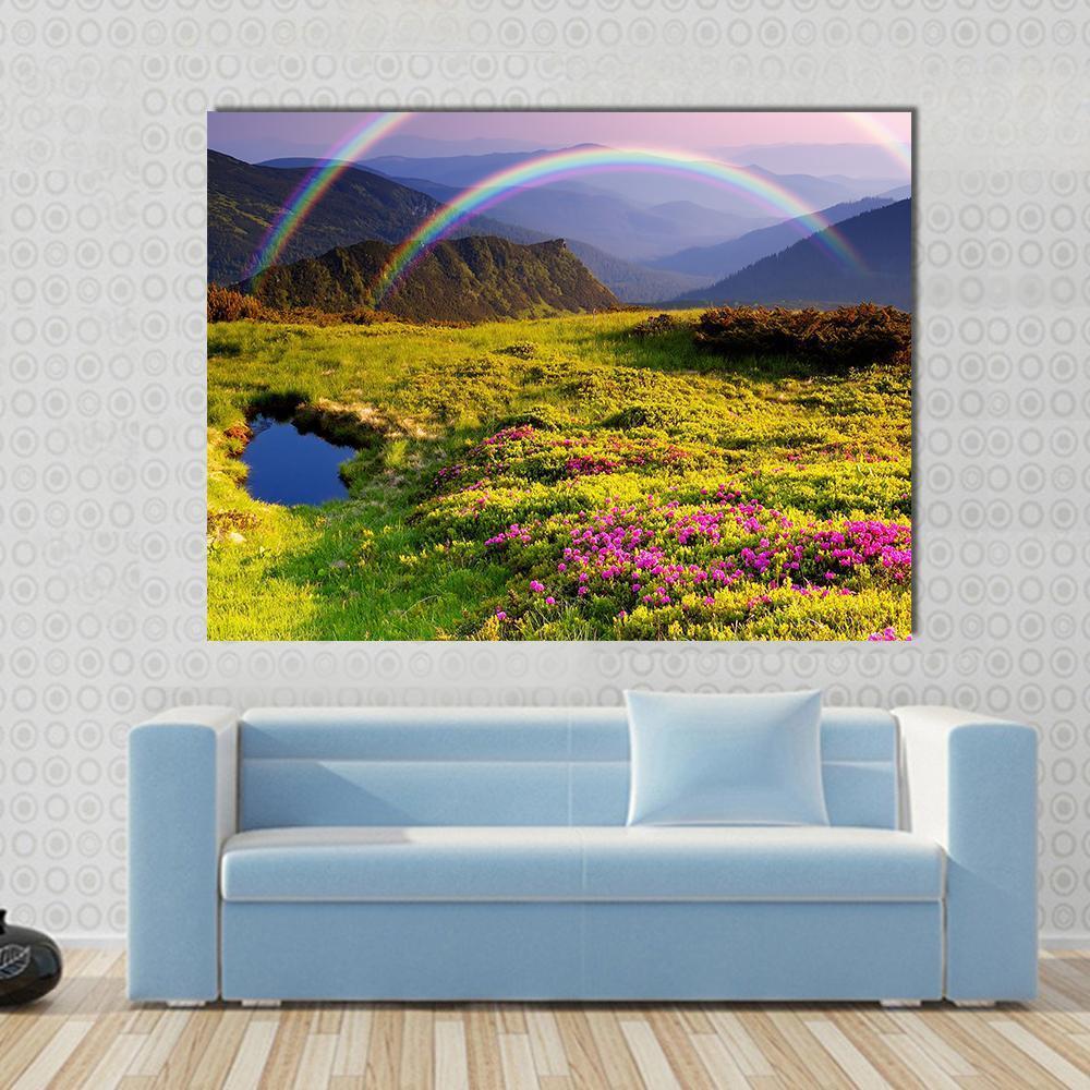 Summer Landscape with Mountains Flowers Rainbow and Lake Canvas Wall Art in green, blue and purple, single panel hung on a wall