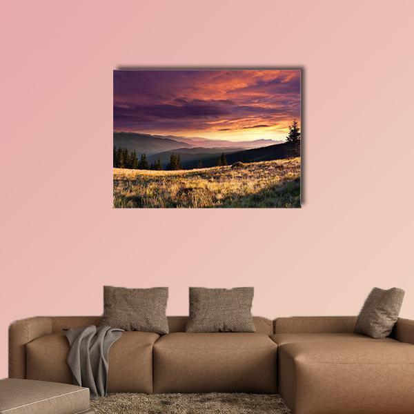 Summer Mountain Sunset Over Meadow Canvas Wall Art in orange, yellow and purple, single panel hung on a wall