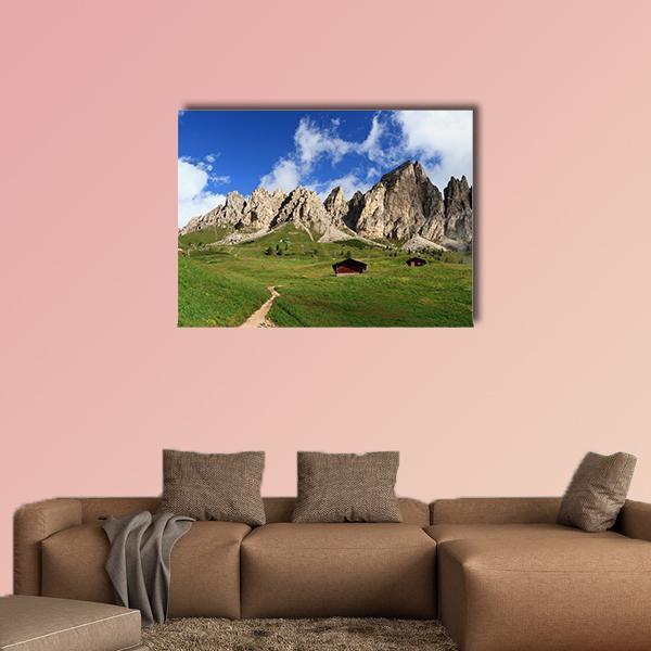 Summer Mountain Meadow with Two Wooden Cabins Canvas Wall Art in gray, green and blue, single panel hung on a wall