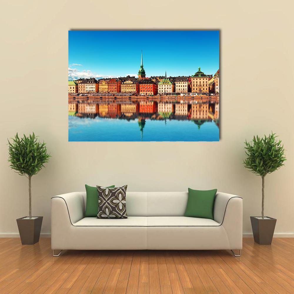Gamla Stan, Stockholm Waterfront Reflections Canvas Wall Art in orange, yellow and blue, single panel hung on a wall