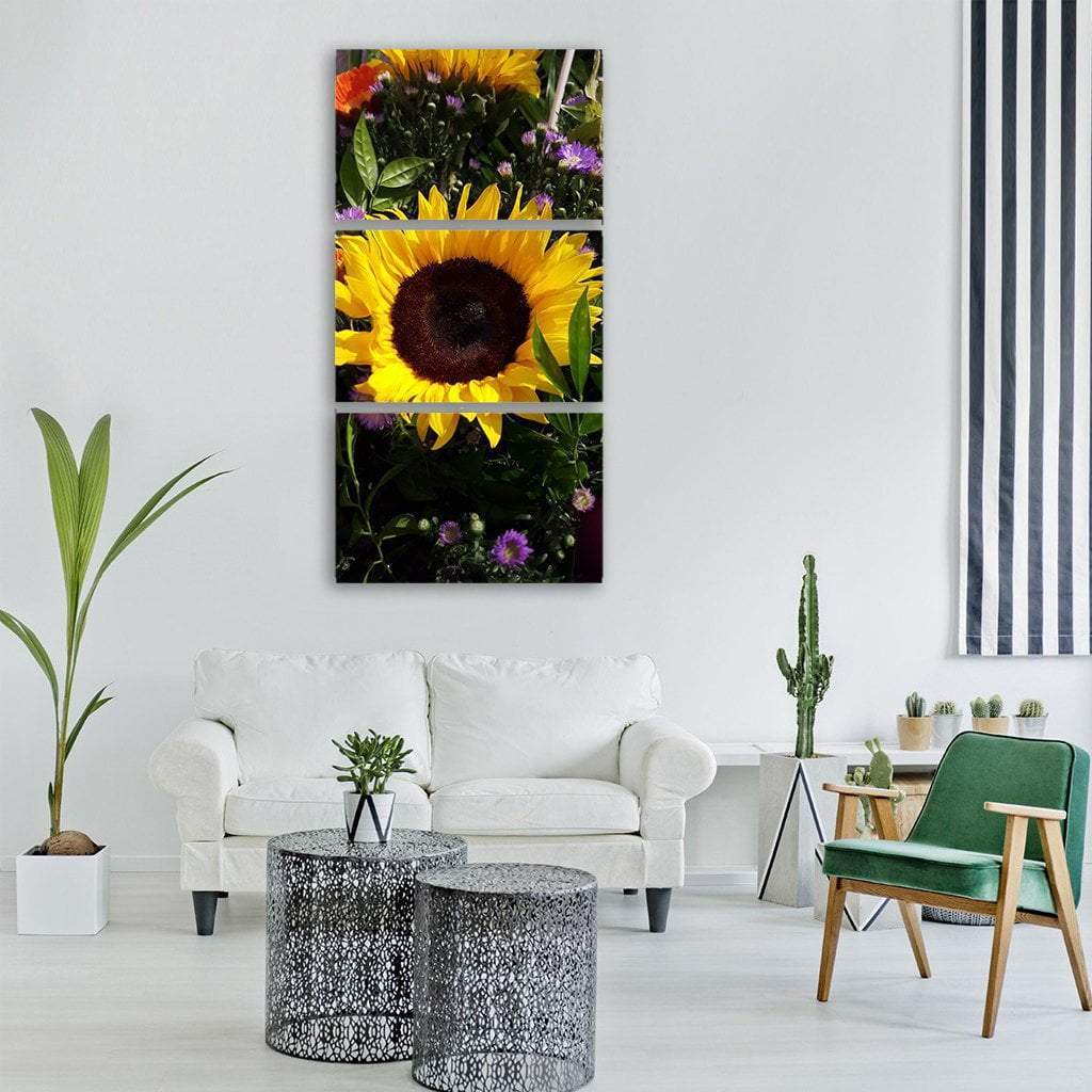 Sunflower Close-up with Wildflowers Vertical Canvas Wall Art in yellow, green and purple, single vertical panel hung on a wall