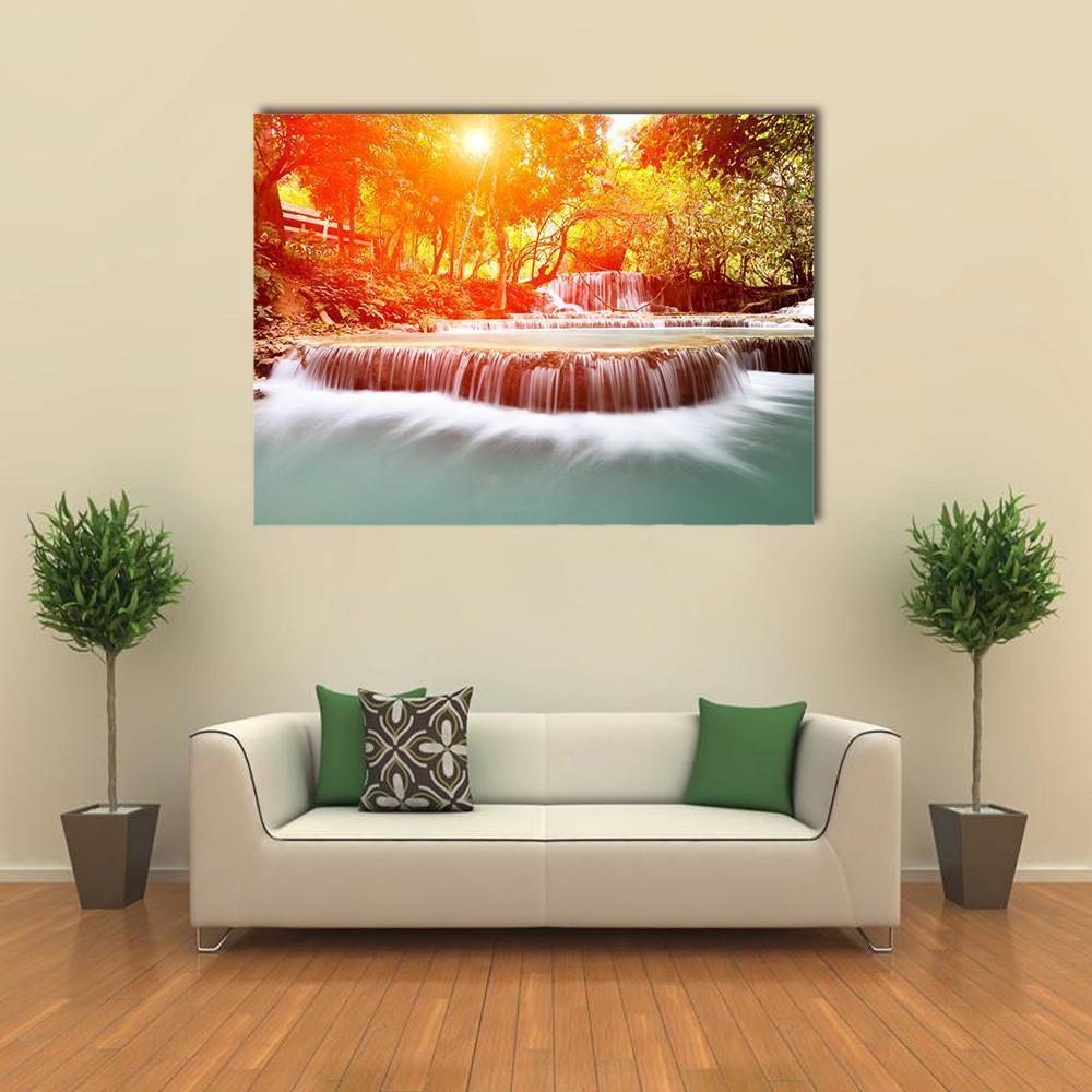 Sunlit Tadklangsi Waterfall Canvas Wall Art in white, orange and green, single panel hung on a wall
