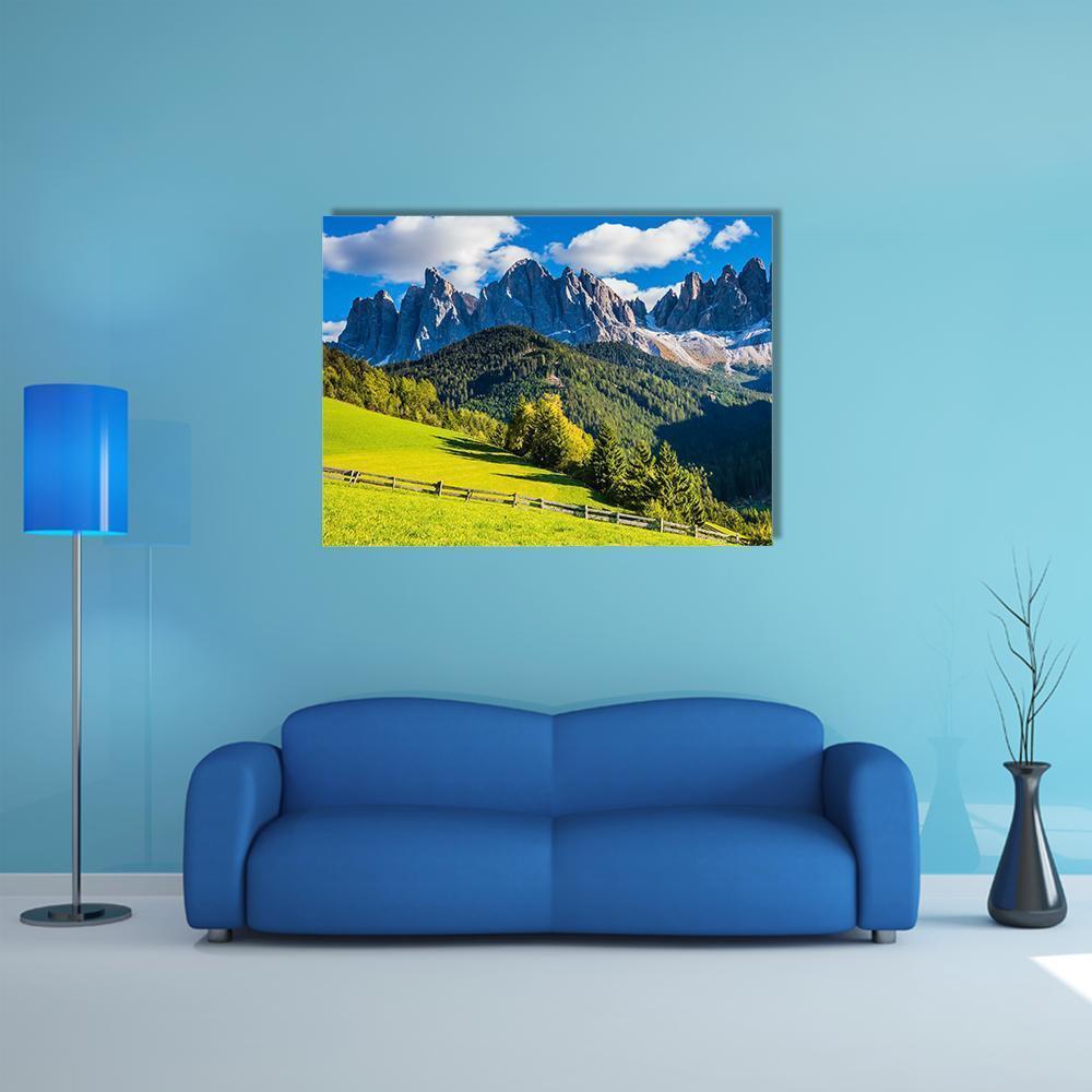 Sunlit Mountain Meadow with Jagged Peaks Canvas Wall Art in gray, green and blue, single panel hung on a wall
