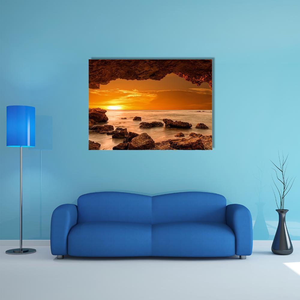 Sunset Through a Sea Cave Canvas Wall Art in brown, orange and yellow, single panel hung on a wall