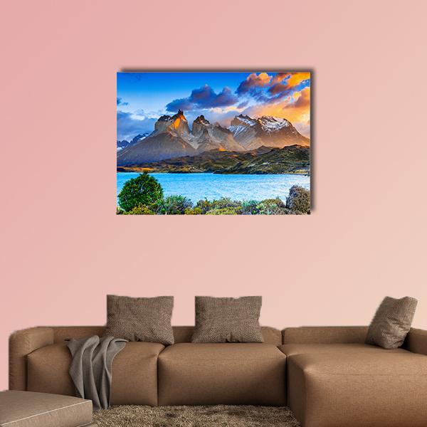 Sunrise Over Snow-capped Mountain Lake Canvas Wall Art in brown, orange and blue, single panel hung on a wall