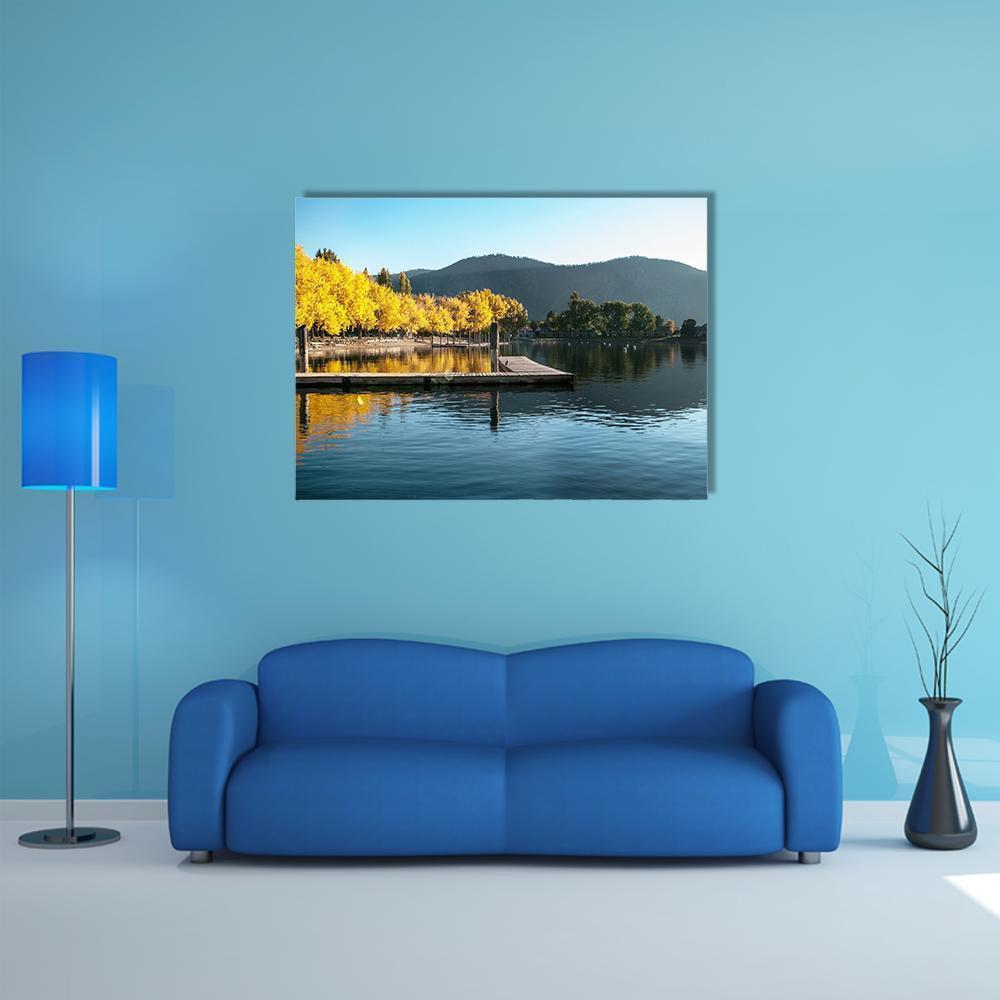 Fall Sunrise Over Lake with Wooden Dock Canvas Wall Art in orange, yellow and blue, single panel hung on a wall