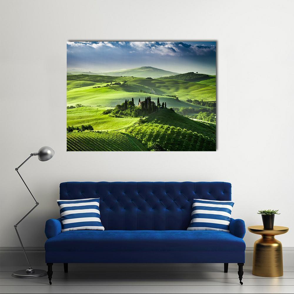 Sunrise Over San Quirico D Orcia Valley Canvas Wall Art in yellow, green and blue, single panel hung on a wall