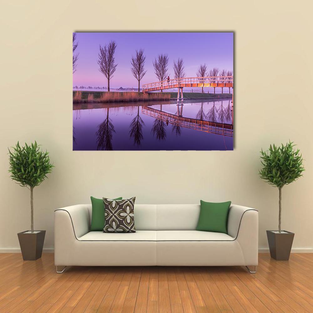 Sunrise on a Canal Bridge in Holland Canvas Wall Art in orange, purple and pink, single panel hung on a wall