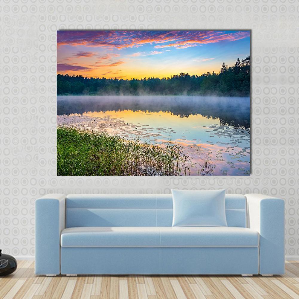 Sunrise Over Forest Lake Canvas Wall Art in orange, yellow and blue, single panel hung on a wall