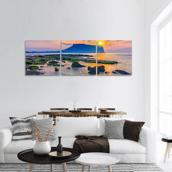 Jeju Island Sunrise Over Coastal Silhouette Panoramic Canvas Wall Art in orange, yellow and blue, hung on a wall