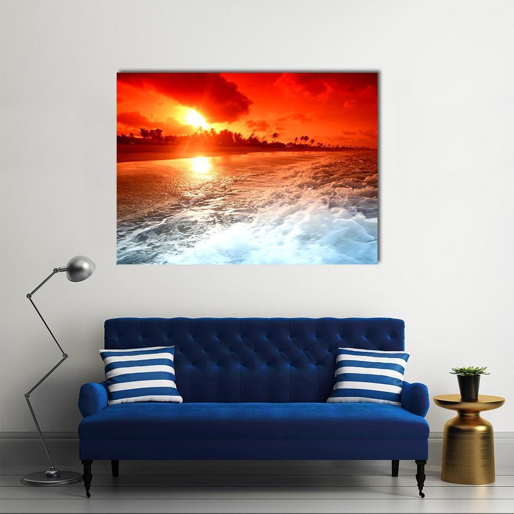 Golden Sunrise Over Tropical Beach Canvas Wall Art in red, orange and yellow, single panel hung on a wall