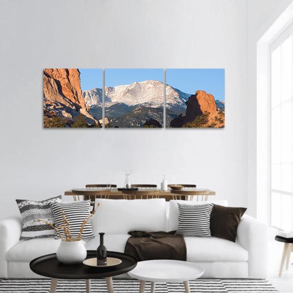 Sunrise Over Snow-capped Peak and Red Rocks Panoramic Canvas Wall Art in white, orange and blue, hung on a wall