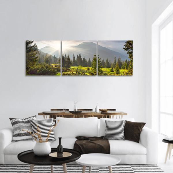 Summer Sunrise Over Mountain Meadow Panoramic Canvas Wall Art in yellow, green and blue, hung on a wall