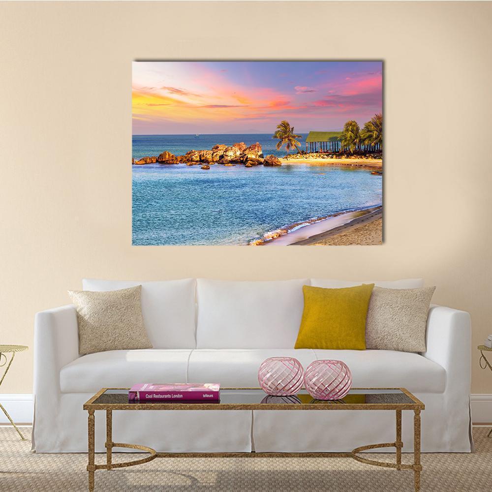 Tropical Sunset Beach Landscape Canvas Wall Art in orange, blue and pink, single panel hung on a wall