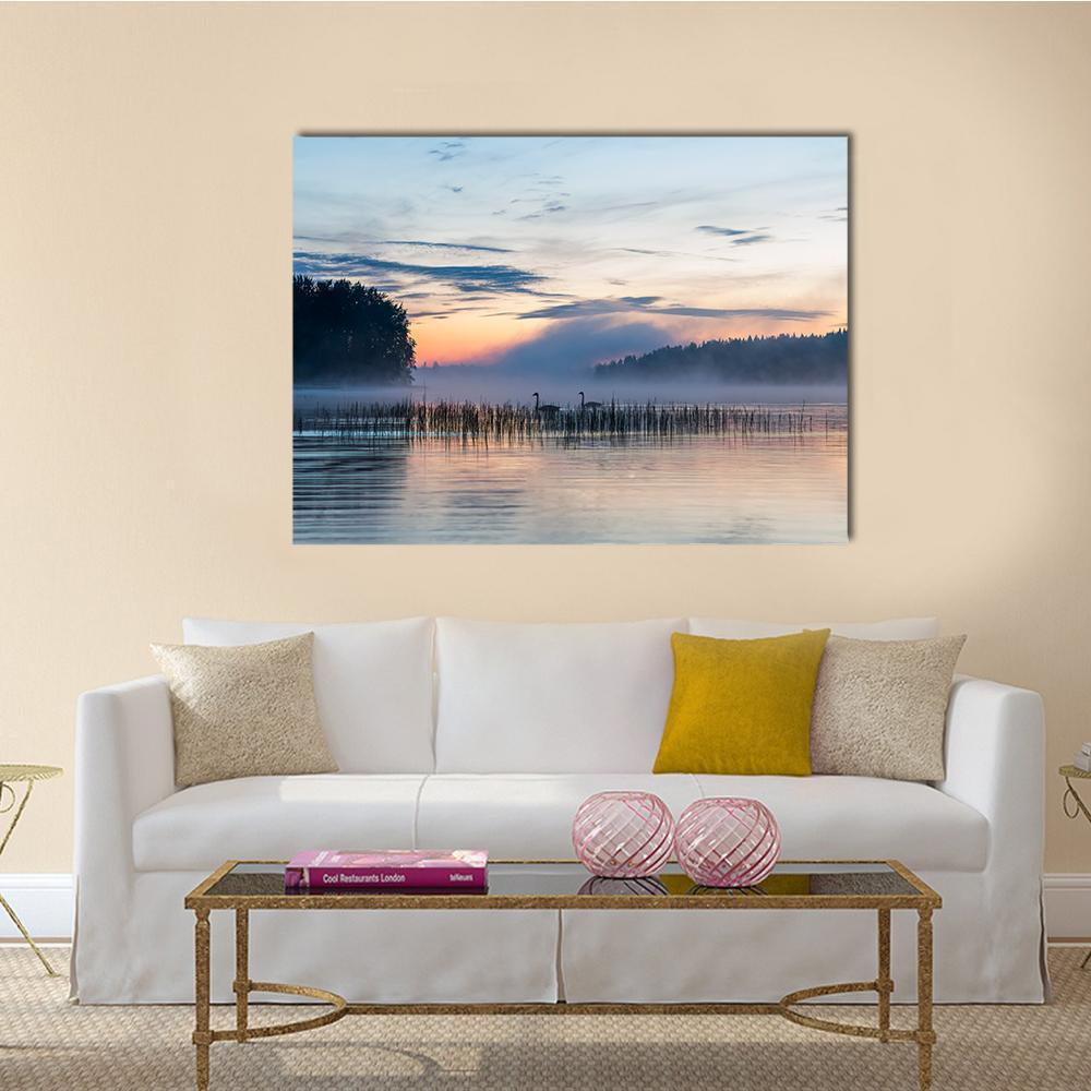 Misty Lake with Swans and Reeds Canvas Wall Art in gray, orange and blue, single panel hung on a wall