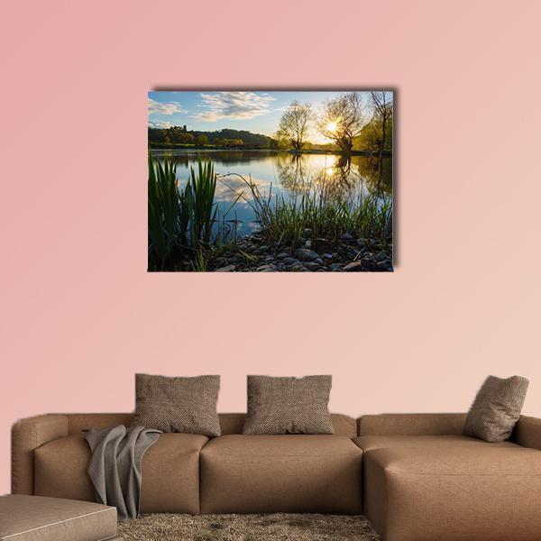 Sunset Over Calm Lake Canvas Wall Art in yellow, green and blue, single panel hung on a wall