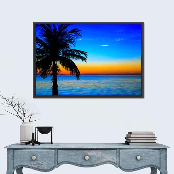 Palm Tree Sunset Over Sea Canvas Wall Art in orange, yellow and blue, framed canvas, product view on a white background