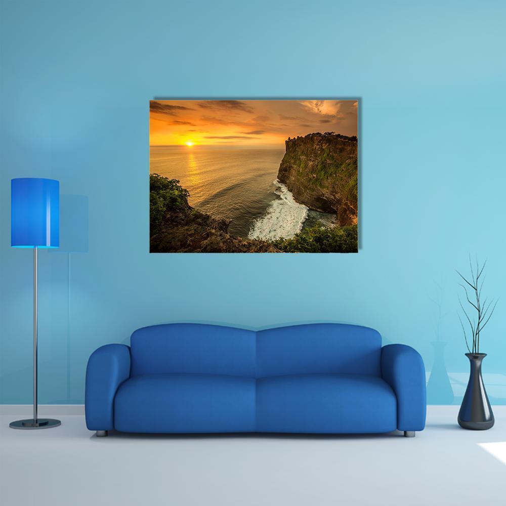Uluwatu Temple Sunset Over Ocean Cliffs Canvas Wall Art in brown, orange and yellow, single panel hung on a wall