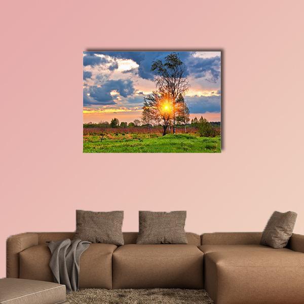 Summer Field at Sunset Canvas Wall Art in orange, green and blue, single panel hung on a wall