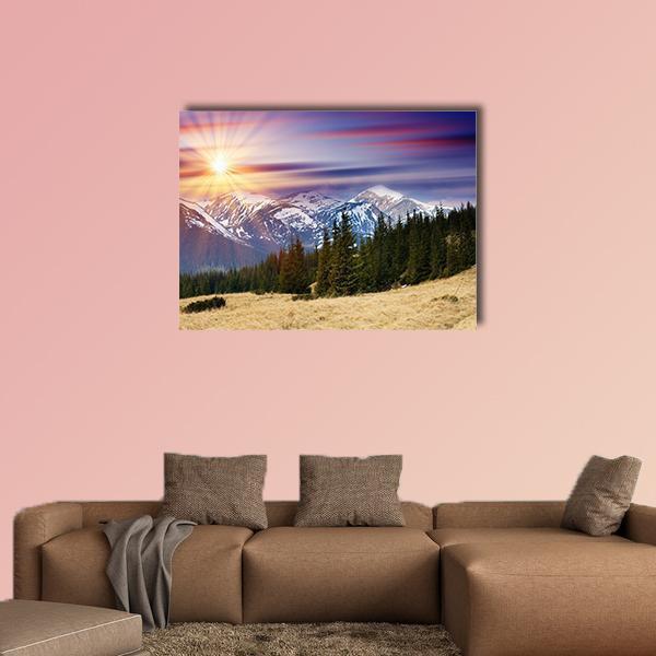 Snowy Mountain Sunrise with Sun Rays Canvas Wall Art in orange, blue and purple, single panel hung on a wall