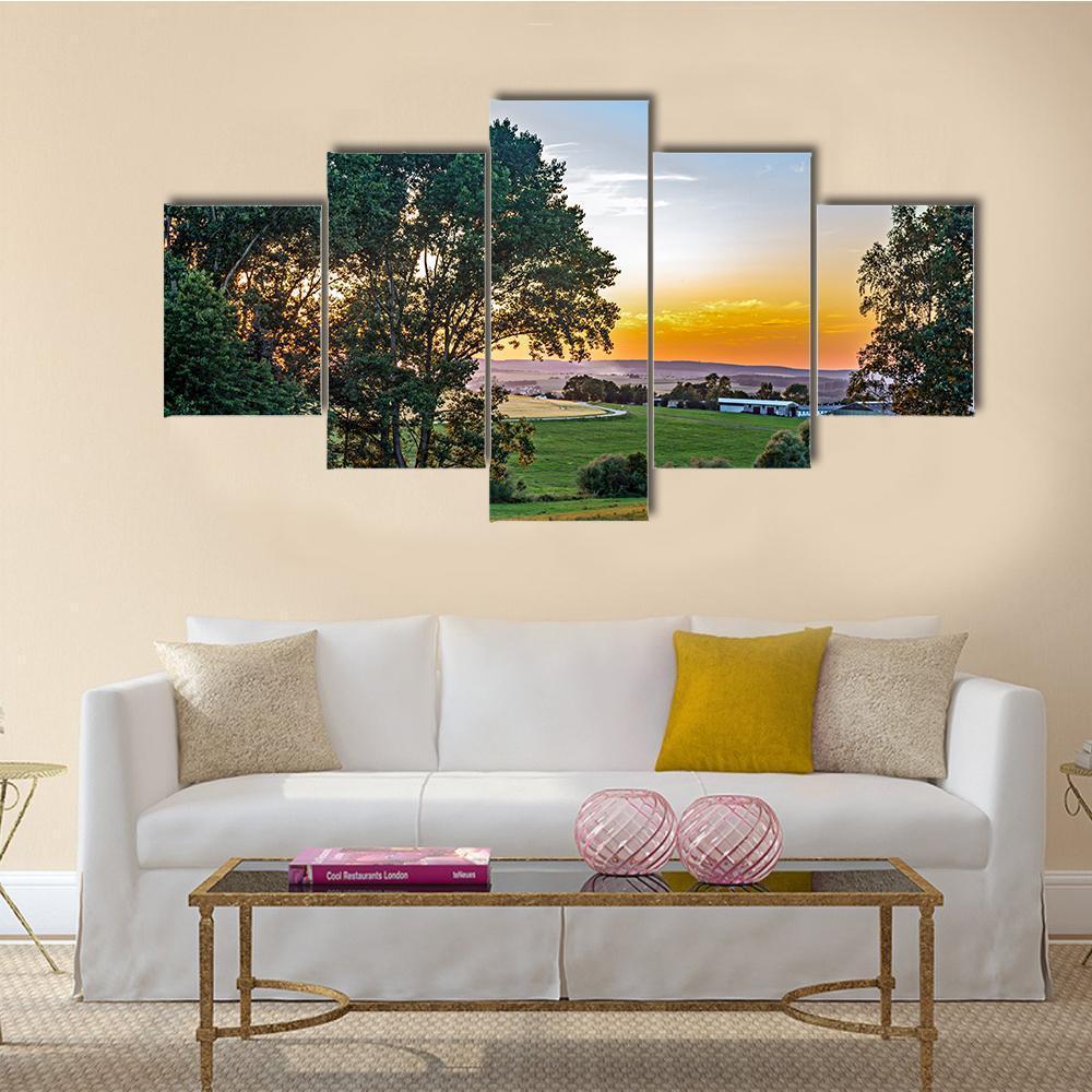Summer Sunset Over Rolling Hills Canvas Wall Art in orange, green and blue, 5 panel Star layout hung on a wall