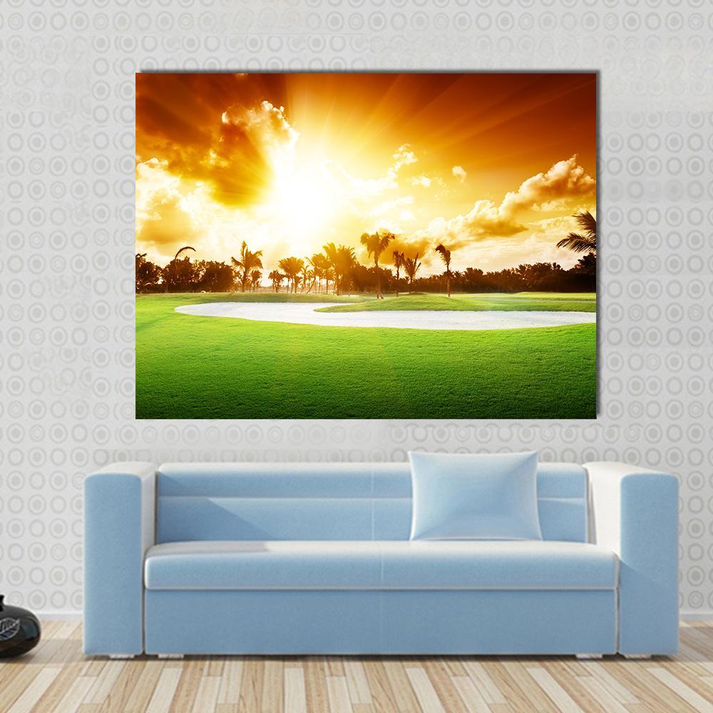 Sunset on Golf Field Canvas Wall Art in orange, yellow and green, single panel hung on a wall