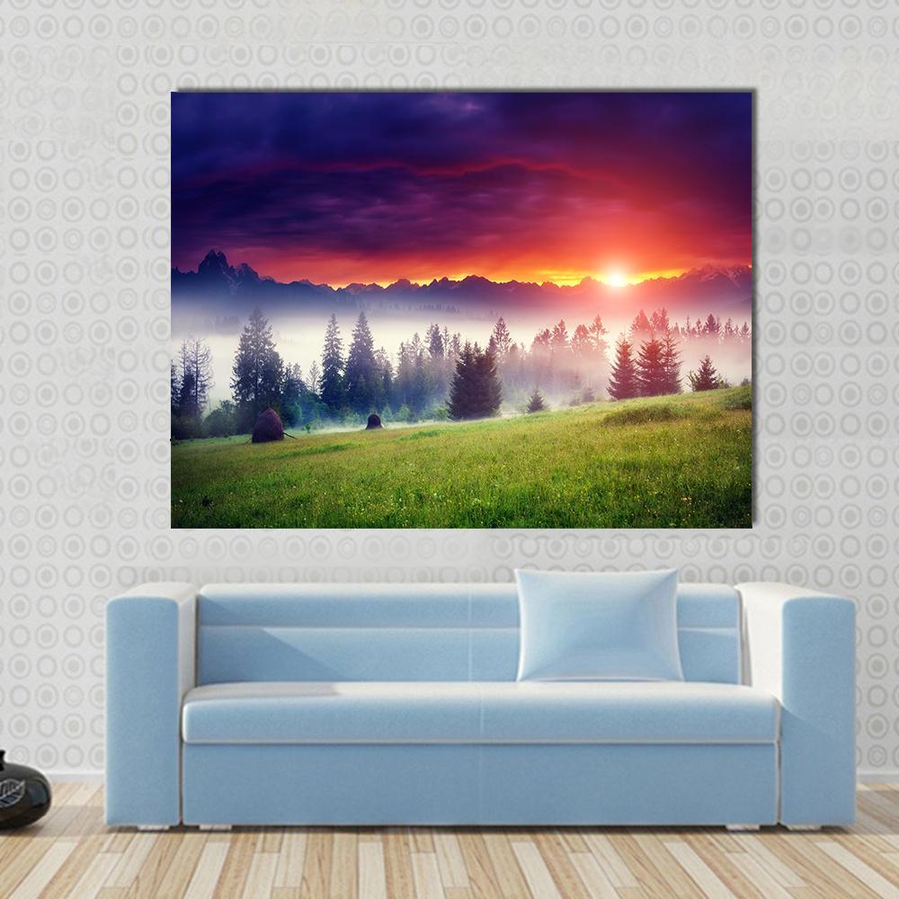 Sunset Over Hilly Mountains Canvas Wall Art in orange, green and purple, single panel hung on a wall