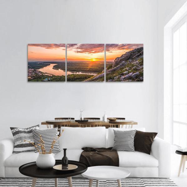Sunset Over Mountain River Valley Panoramic Canvas Wall Art in gray, orange and green, hung on a wall