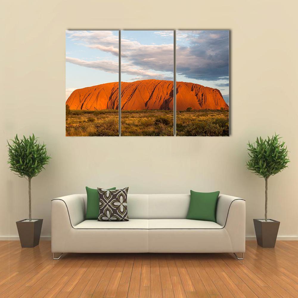 Sunset Over Ayers Rock Canvas Wall Art in brown, orange and blue, 3 panel horizontal set hung on a wall