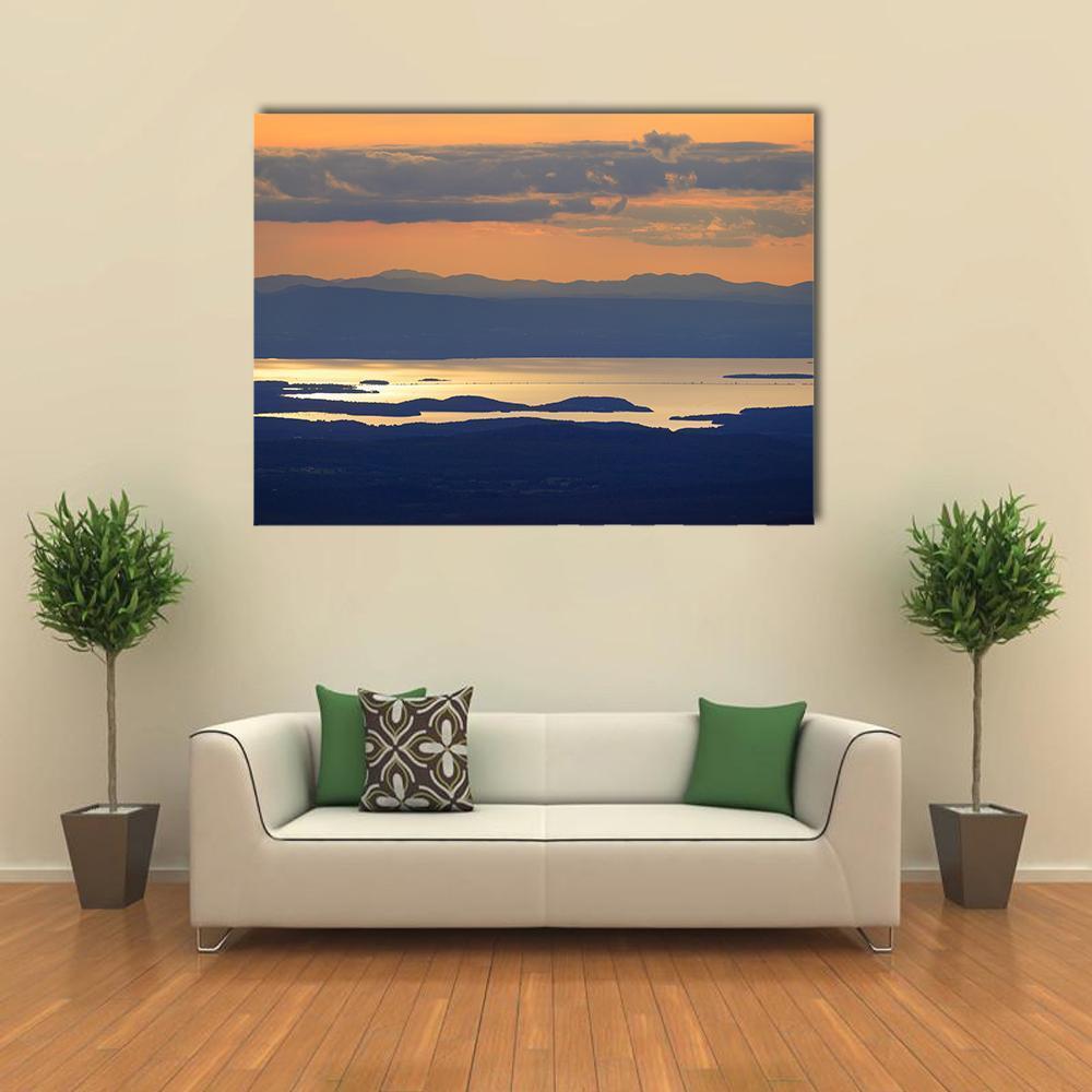 Lake Champlain Sunset Canvas Wall Art in orange, blue and navy, single panel hung on a wall