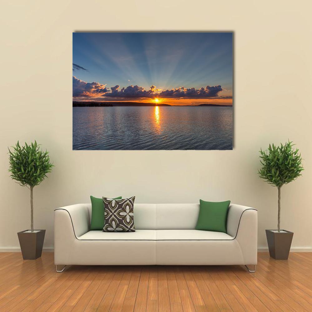 Sunset Over Lake Canvas Wall Art in orange, yellow and blue, single panel hung on a wall