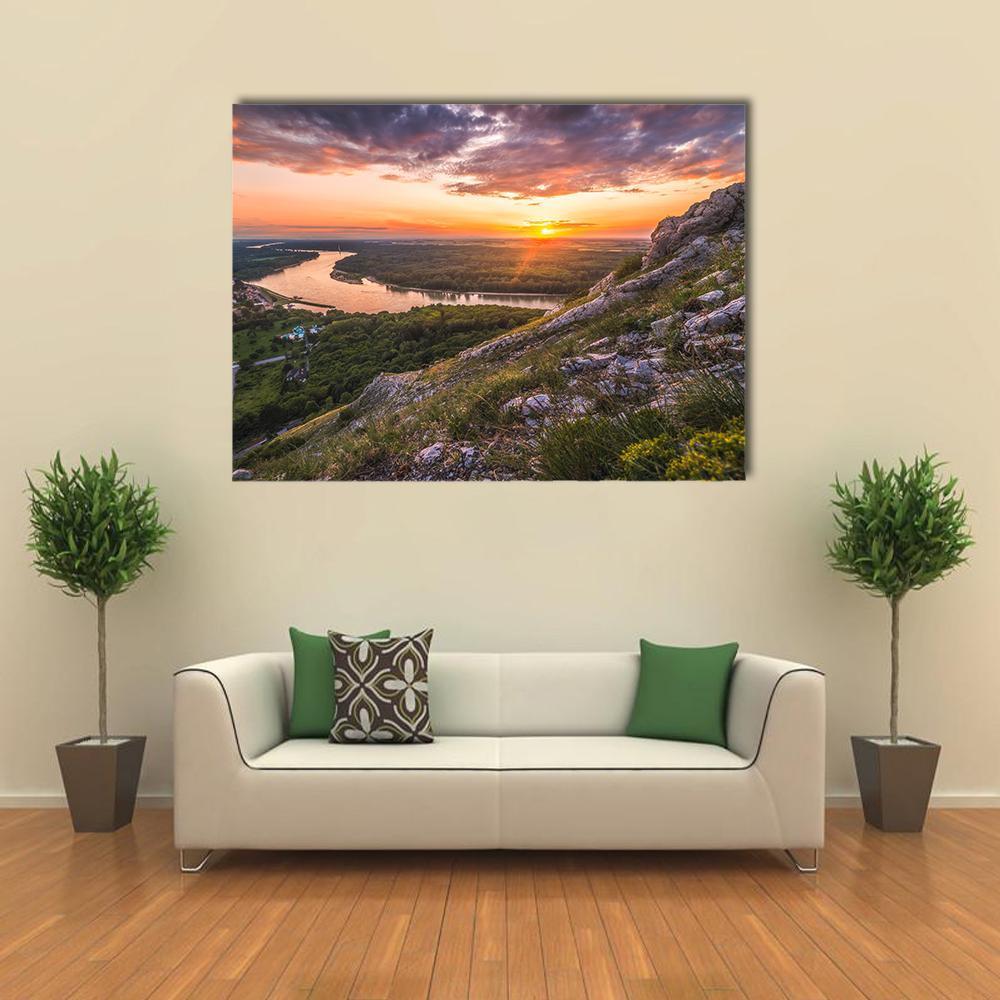 Sunset Over Rocky River Canvas Wall Art in gray, orange and green, single panel hung on a wall