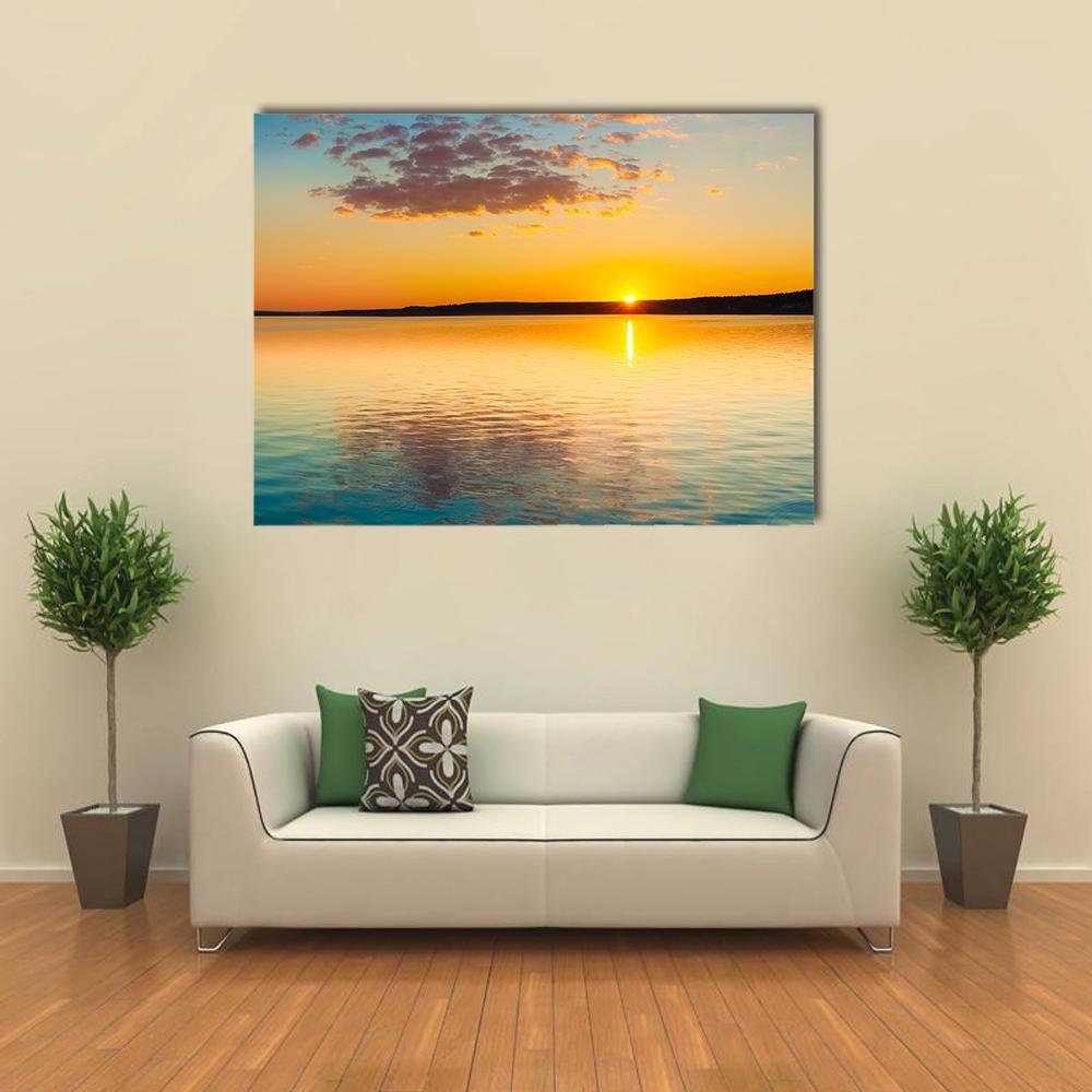 Golden Sunset Over Lake Canvas Wall Art in orange, yellow and blue, single panel hung on a wall