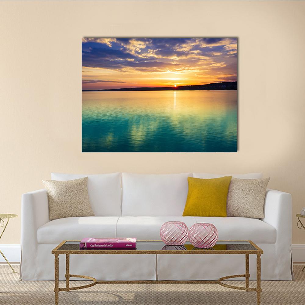 Sunset Over River with Reflection Canvas Wall Art in orange, yellow and blue, single panel hung on a wall