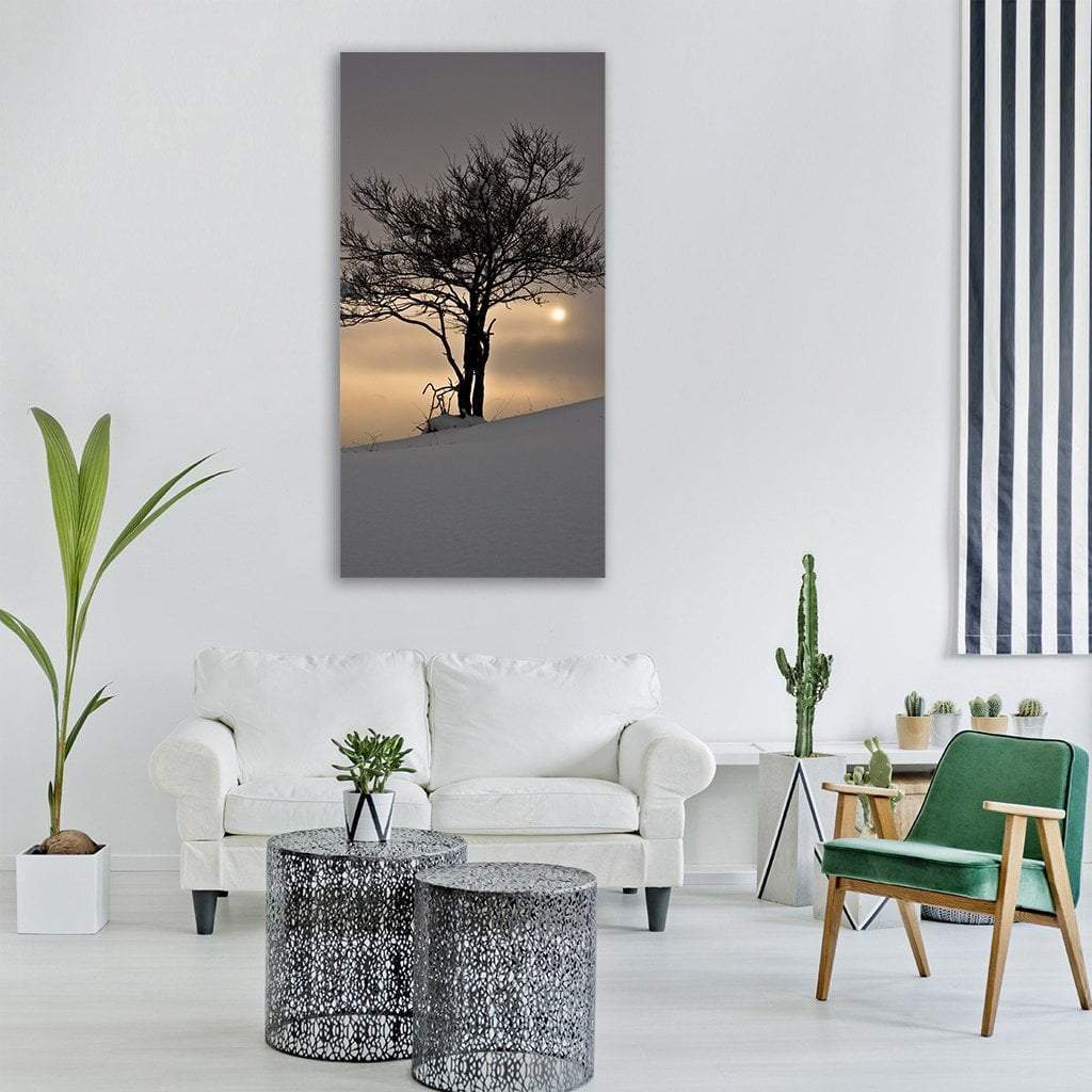 Lone Tree on Snowy Hill at Sunrise Vertical Canvas Wall Art in white, gray and gold, single vertical panel hung on a wall