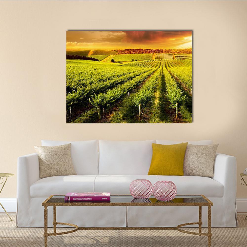 Sunset Over Vineyard Canvas Wall Art in orange, yellow and green, single panel hung on a wall