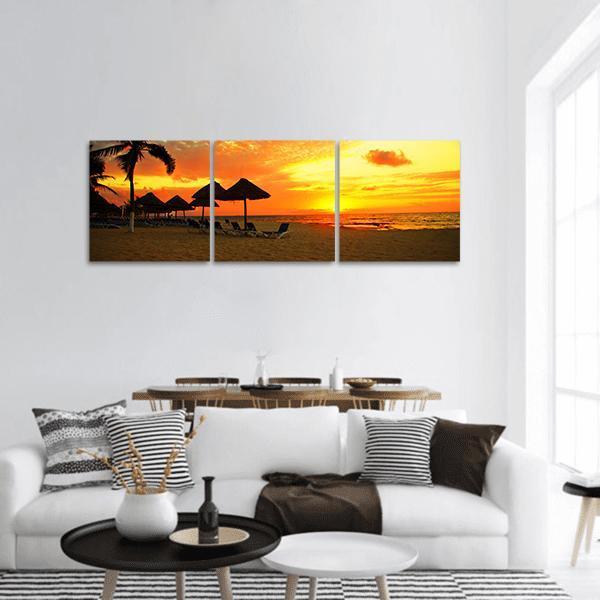 Tropical Beach Sunset Panoramic Canvas Wall Art in black, orange and yellow, hung on a wall