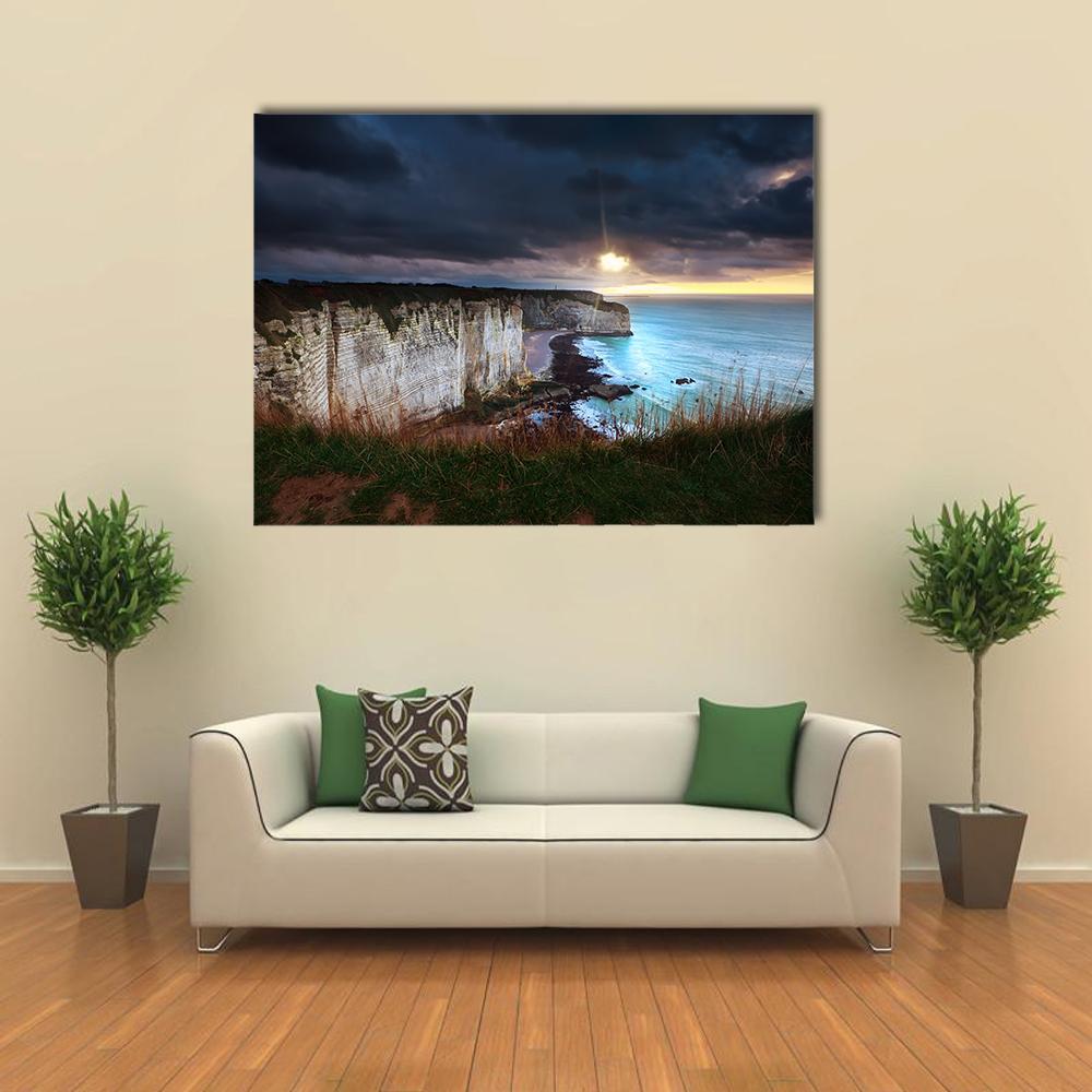 Sun Breaking Through Storm Over Coastal Cliffs Canvas Wall Art in black, gray and blue, single panel hung on a wall