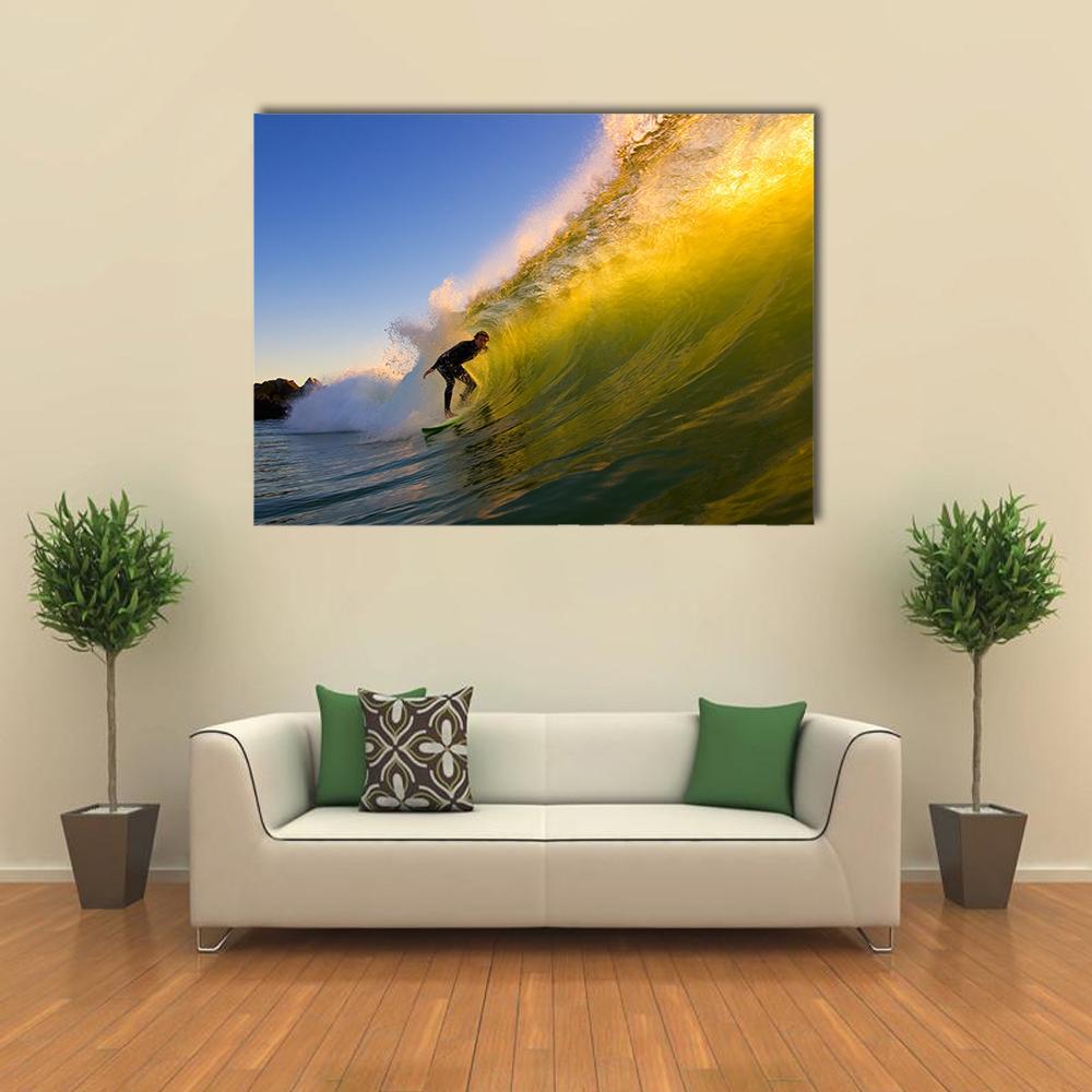 Surfer in Barrel at Sunset Canvas Wall Art in yellow, green and blue, single panel hung on a wall