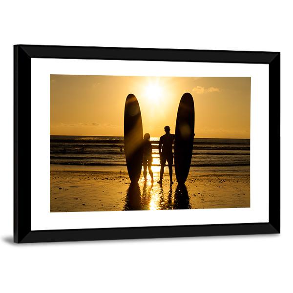Surfer Couple Holding Long Surf Boards At Sunset On Beach Canvas Wall Art-3 Horizontal-Gallery Wrap-25" x 16"-Tiaracle