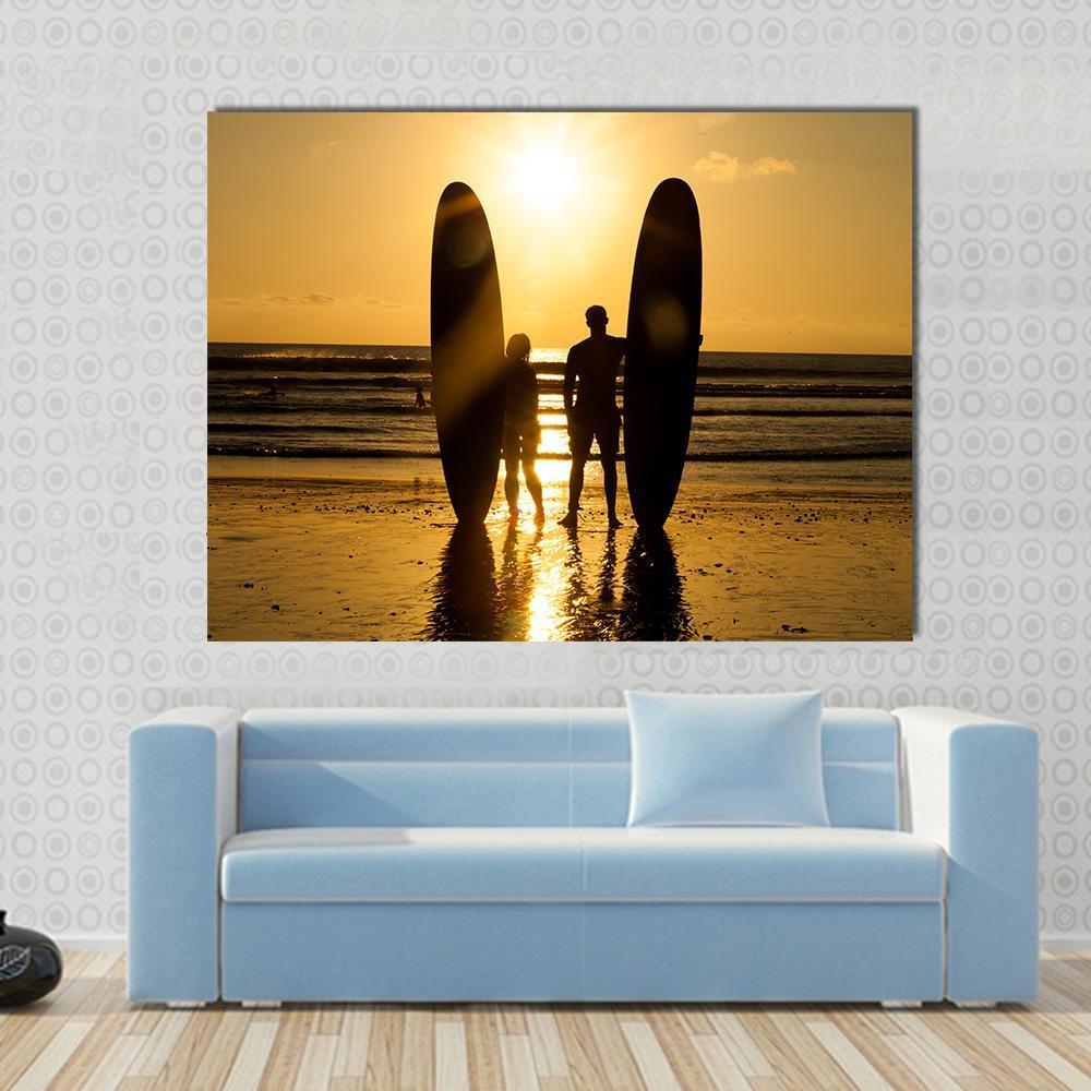 Surfer Couple Holding Long Surf Boards At Sunset On Beach Canvas Wall Art-1 Piece-Gallery Wrap-48" x 32"-Tiaracle