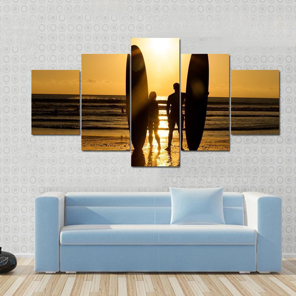 Surfer Couple Holding Long Surf Boards At Sunset On Beach Canvas Wall Art-1 Piece-Gallery Wrap-48" x 32"-Tiaracle