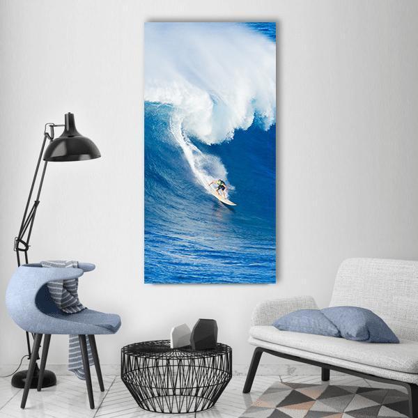 Surfer Riding Giant Curling Wave Vertical Canvas Wall Art in white and blue, single vertical panel hung on a wall