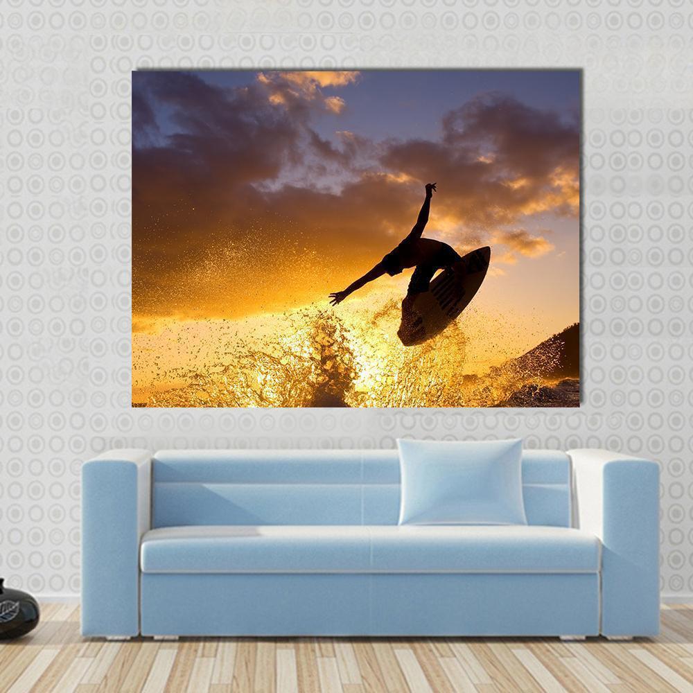 Surfer Mid-air at Sunset Canvas Wall Art in orange, yellow and blue, single panel hung on a wall