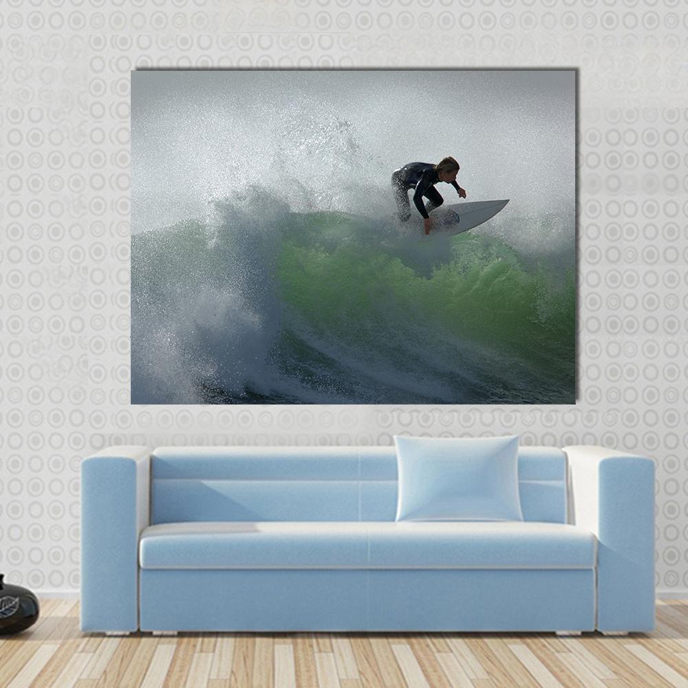 Surfer Riding a Translucent Green Wave Canvas Wall Art in white, gray and green, single panel hung on a wall