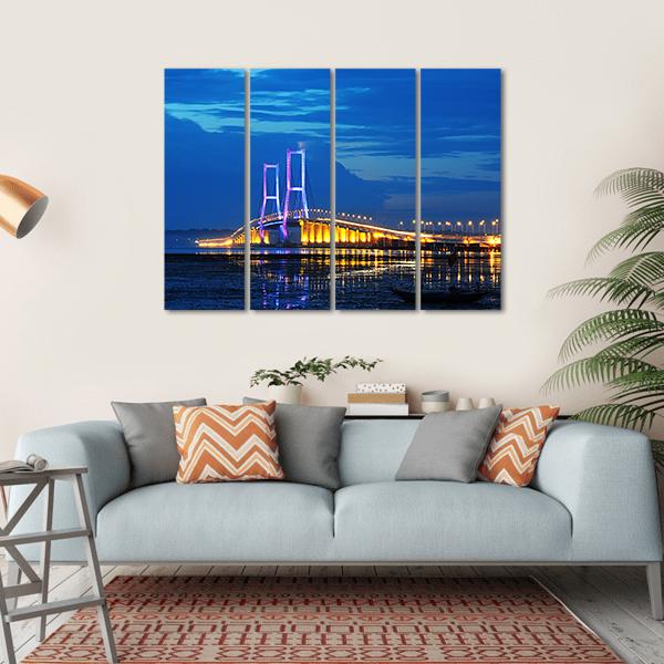 Surmadu Bridge Night Reflection Canvas Wall Art in black, yellow and blue, hung on a wall