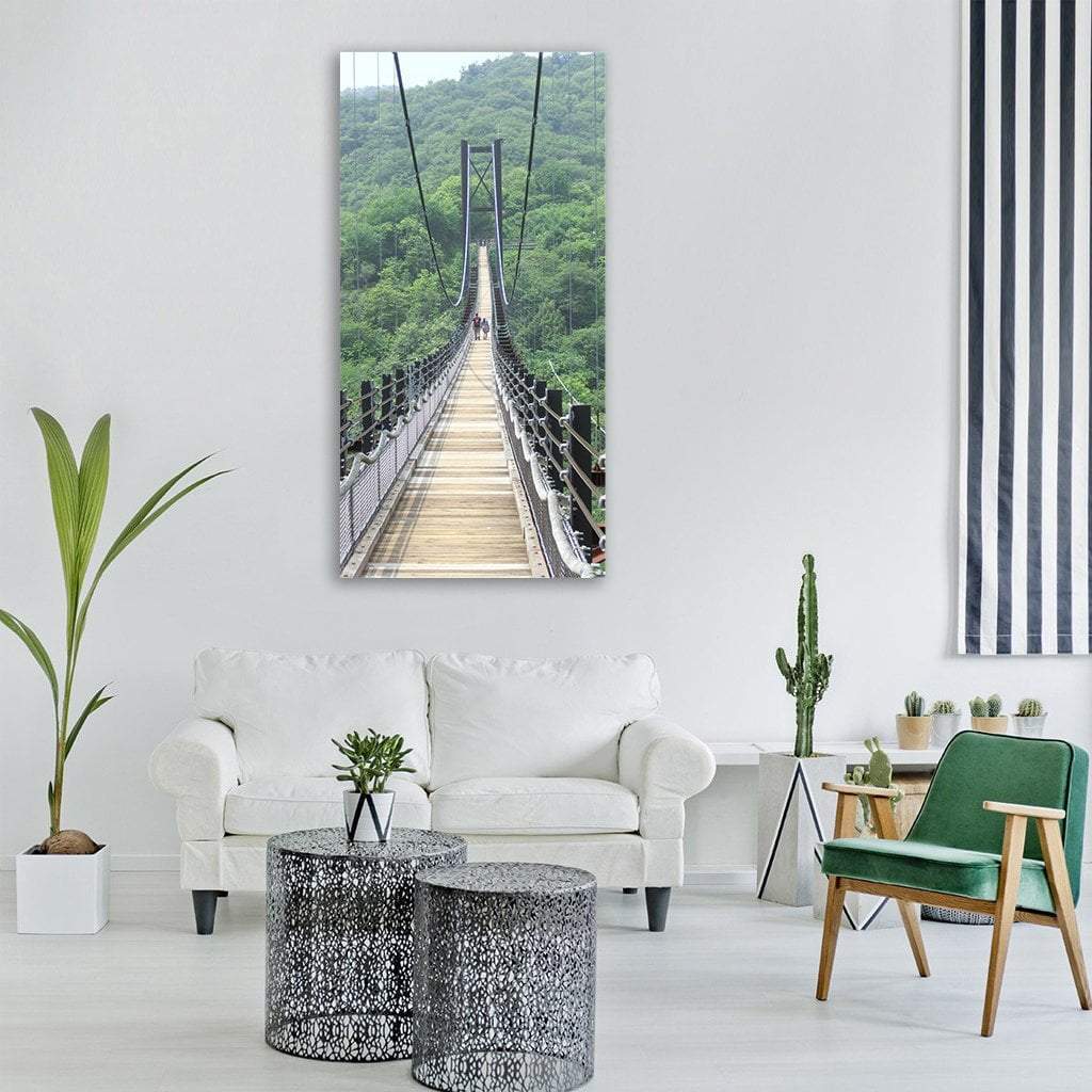 Deep Forest Suspension Bridge Vertical Canvas Wall Art in gray, brown and green, single vertical panel hung on a wall