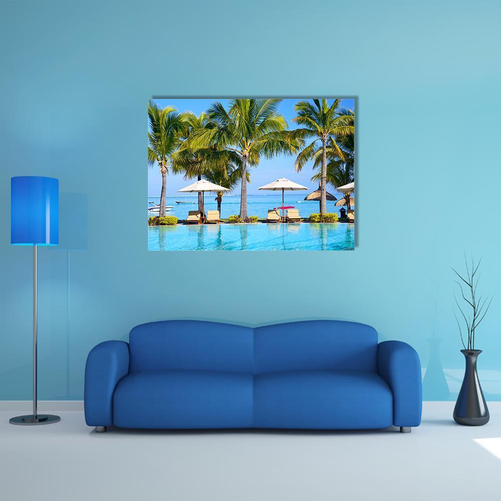 Swimming Pool with Lounge Chairs and Palm Trees Canvas Wall Art in green and blue, single panel hung on a wall