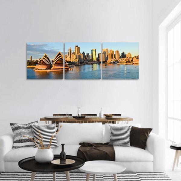 Sydney Opera House and Harbor Skyline Panoramic Canvas Wall Art in gold, orange and blue, hung on a wall