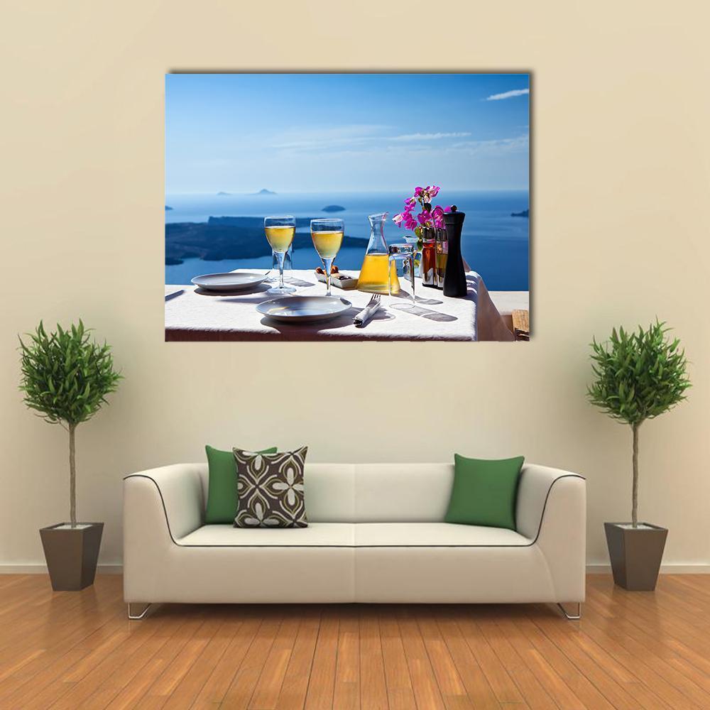 Table Setting Overlooking Santorini Sea Canvas Wall Art in white, yellow and blue, single panel hung on a wall